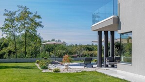 A modern outdoor patio with lounge chairs, a small tree, and a concrete pathway. - Amazing home in Labin with private swimming pool, can be inside or outside (Labin)