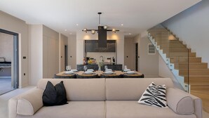 A modern living room with a sofa, a dining area with a table set for four, and a staircase. - Amazing home in Labin with private swimming pool, can be inside or outside (Labin)