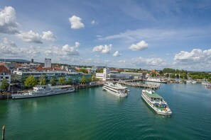 A river with two large cruise ships docked, surrounded by modern buildings and a clear sky.