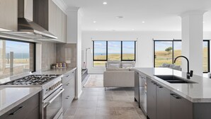 Una cocina moderna con una isla grande, horno integrado y vistas al exterior.