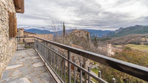 A stone staircase leading to a balcony overlooking a mountainous landscape with traditional buildings. - Country House 'Sisquet' with Mountain View, Private Terrace and Wi-Fi (Montcortès)