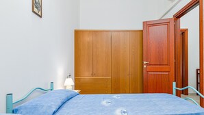 Une chambre à coucher avec un lit, une armoire en bois et une porte.