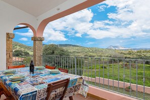 A balcony with a table set for dining, overlooking a mountainous landscape. - Holiday Home 'Piano Primo Lu Carrulu' with Mountain View, Private Terrace and Air Conditioning (san teodoro)