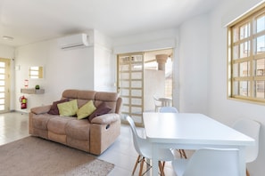 Una sala de estar moderna con un sofá, una mesa de comedor y sillas.
