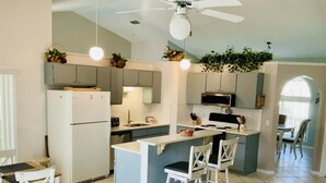 A modern kitchen with a central island, white cabinetry, and a ceiling fan. - Amazing 3/2 Vacation Home With Private Pool!! (Davenport)