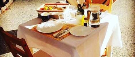 A table set for two with plates, cutlery, and a coffee pot.