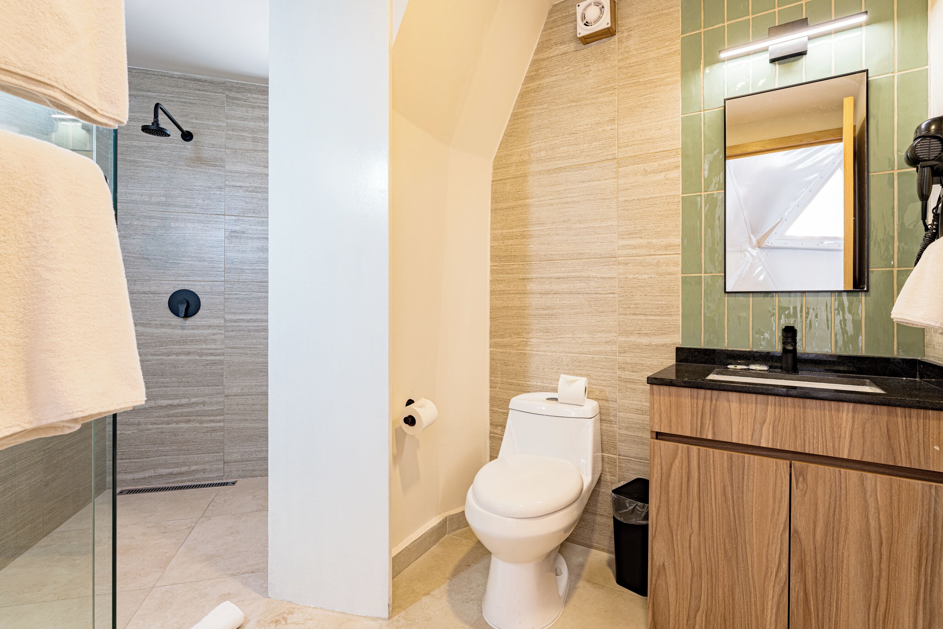 A modern bathroom with a toilet, sink, and shower.