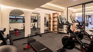 A gym with exercise equipment, mirrors, and a bench. - Mint Roma Residences (Mexico City)