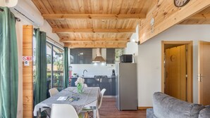 A compact kitchen with modern appliances, a dining area with a table and chairs, and a cozy living space with a sofa.