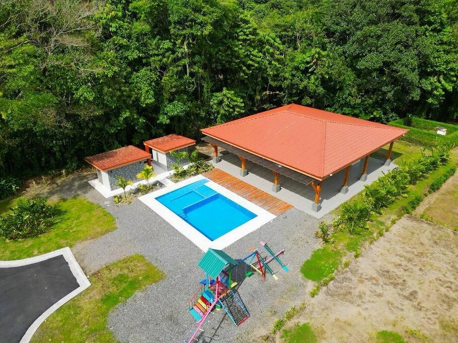 Un resort con piscina, mobiliario exterior y un pabellón cubierto.