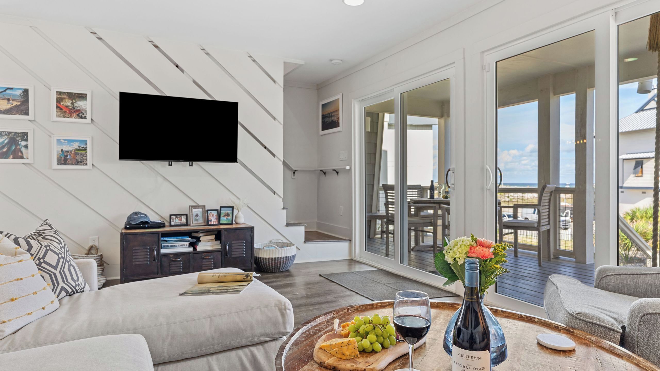 Un salon moderne doté d’un téléviseur à écran plat, d’un coin repas avec une table et des chaises, et d’un balcon offrant une vue agréable.
