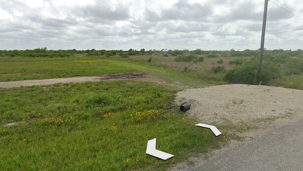 A rural landscape with a gravel road, grassy fields, and a utility pole. - Cozy campground in charming Alamo Beach, Texas (Alamo Beach)
