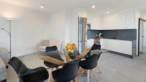 A modern kitchen with white cabinets, a stainless steel refrigerator, and a glass dining table with chairs. - 'Buena - Vista' with Sea Views, Private Pool and Wi-Fi (La Guancha)