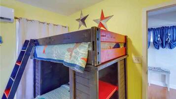 A bunk bed with a ladder, a star decoration, and a curtain.