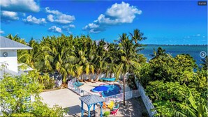 Una proprietà residenziale con piscina, patio coperto e vista sull'oceano.