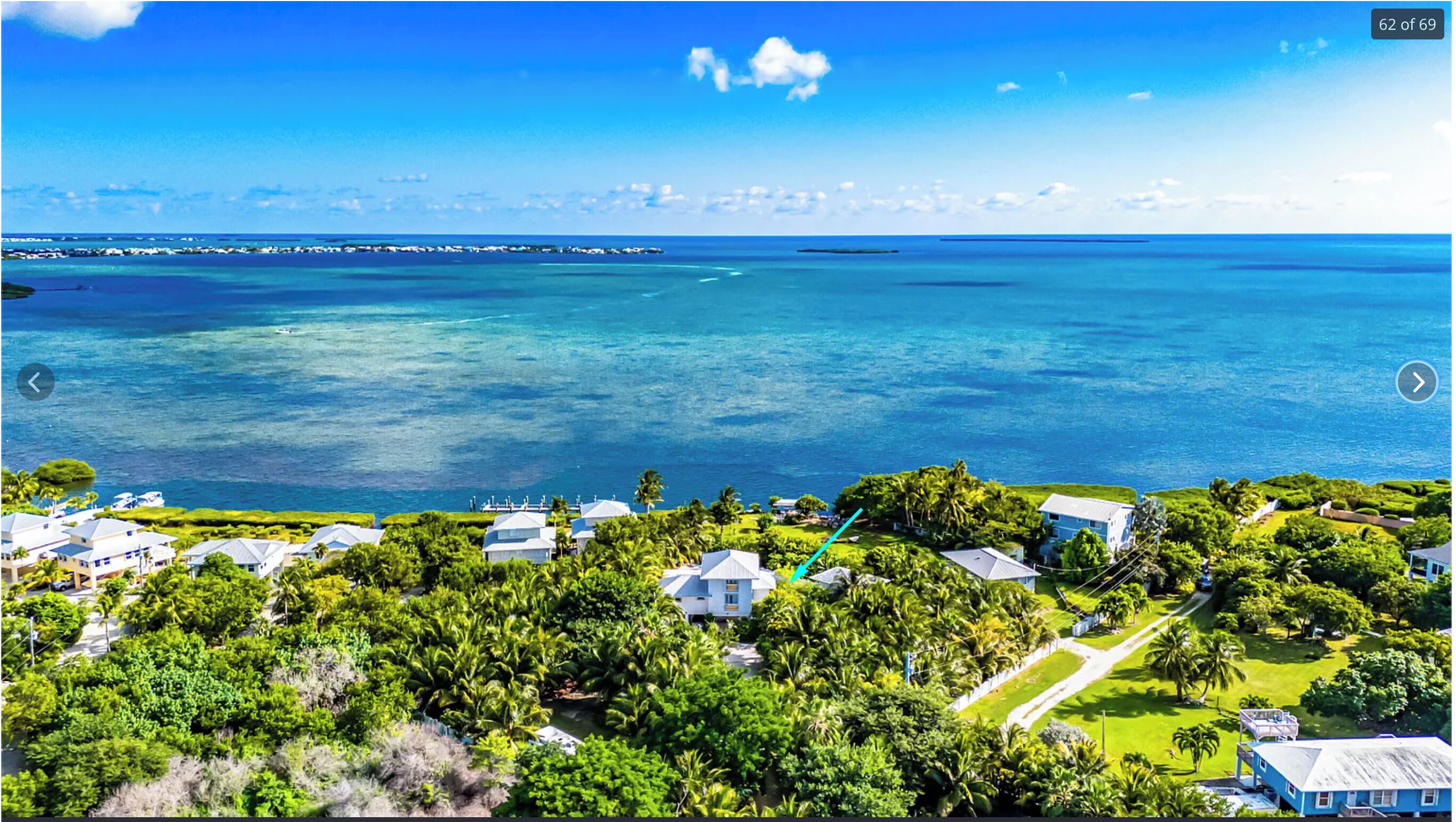 Uma propriedade costeira com várias casas, vegetação exuberante e uma vista clara do oceano.