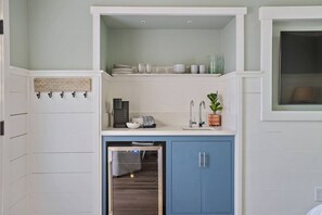 A compact kitchenette with a coffee maker, a sink, and a small oven.