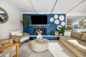 Een moderne woonkamer met een open haard, een televisie en een bank.