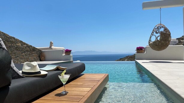 A luxurious outdoor seating area with a pool, overlooking a scenic view of the sea. - Villa Camelia 1 - 1BR - Private Pool & Jacuzzi - Sea View - Psarou (Nammos) (Mykonos)