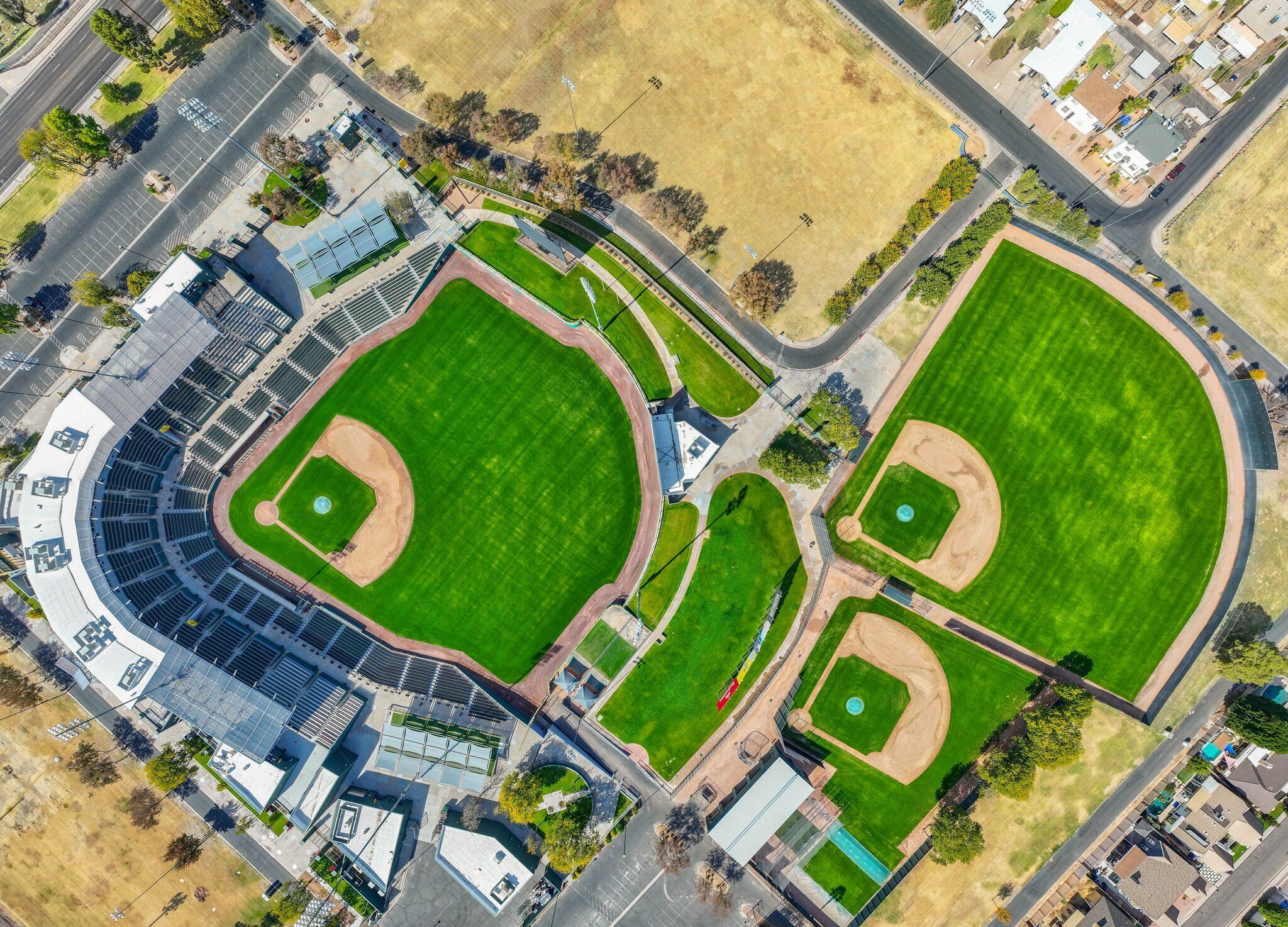 Vue aérienne d’un stade de baseball doté de plusieurs terrains, de zones pour les spectateurs et des infrastructures environnantes.