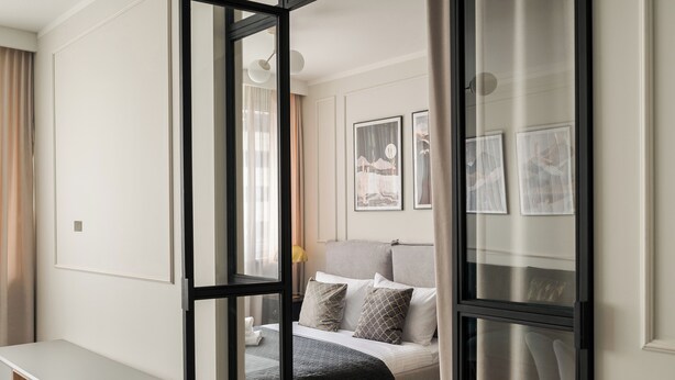 A modern bedroom with a bed, bedside table, and a desk. - Metro Wierzbno Deluxe Apartment (Warszawa)