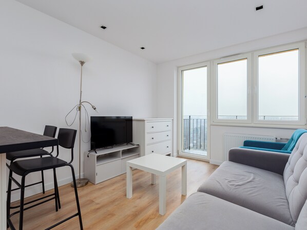 Relax in this stylish living room with a flat-screen TV, dining area, and comfortable sofa.