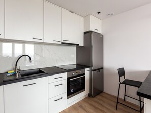 Enjoy cooking in this kitchen with sleek cabinetry, a refrigerator, and oven.