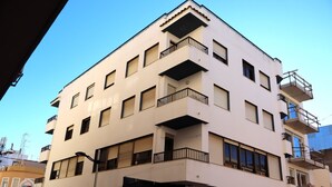 A multi-story building with balconies, a restaurant named "El Rey de las Mariscadas," and a visible storefront. - Los Pescadores playa LEK (Peñiscola)