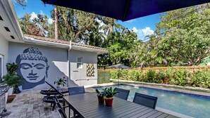 An outdoor patio with a pool, a Buddha mural, and potted plants. - Tropical Oasis, Heated Pool, Near Las Olas Beach (Fort Lauderdale)