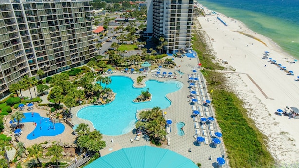 A resort with multiple swimming pools, a beach, and high-rise buildings.