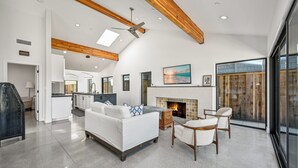 A spacious living room with a fireplace, a sofa, and a dining area.