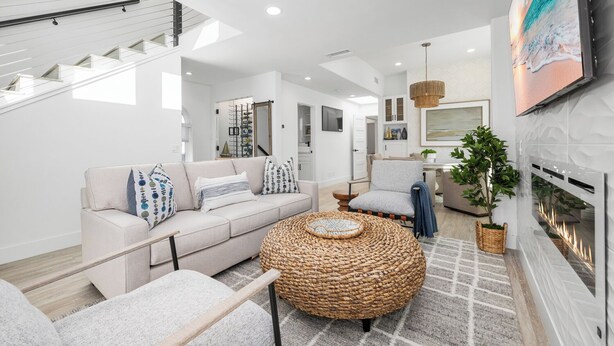 Un salon moderne avec un canapé, une table basse et une cheminée.