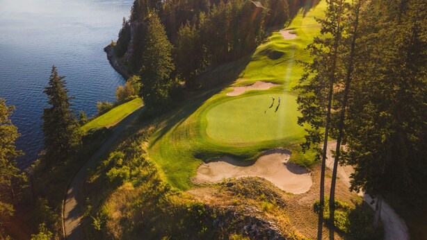 A golf course with a lake, surrounded by dense forest and mountains. - Mara Spring Lodges - Suite 1 (Mara)