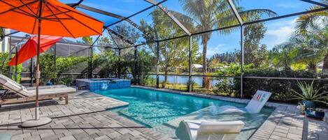 Zona de piscina con vista despejada, sillas de descanso y un área de estar cubierta.