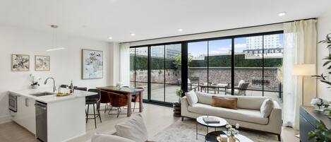 Un apartamento moderno con cocina, comedor y sala de estar. Cuenta con ventanas amplias, un balcón y vistas de la ciudad.
