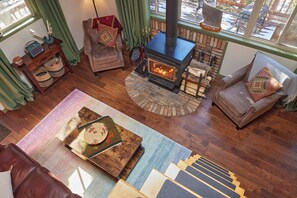 A cozy living room with a fireplace, leather sofas, and a rustic wooden coffee table.