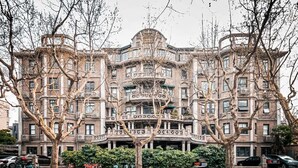 Un immeuble à plusieurs étages, de style architectural classique, doté de balcons et d’une entrée centrale.