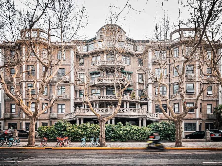 Un immeuble à plusieurs étages, de style architectural classique, doté de balcons et d’une entrée centrale.