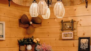 Un interno in legno con un tavolo rotondo, sedie, un lampadario e decorazioni a parete.