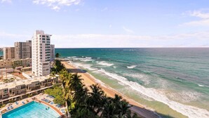 A beachfront hotel with a pool, ocean view, and high-rise buildings in the background. - Chic Studio in Condado | Beach at Your Doorstep (San Juan)