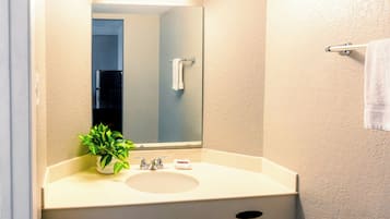 Bañera con ducha, toallas, jabón, shampoo