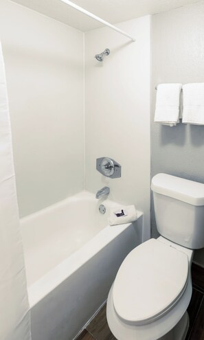 Bañera con ducha, toallas, jabón, shampoo