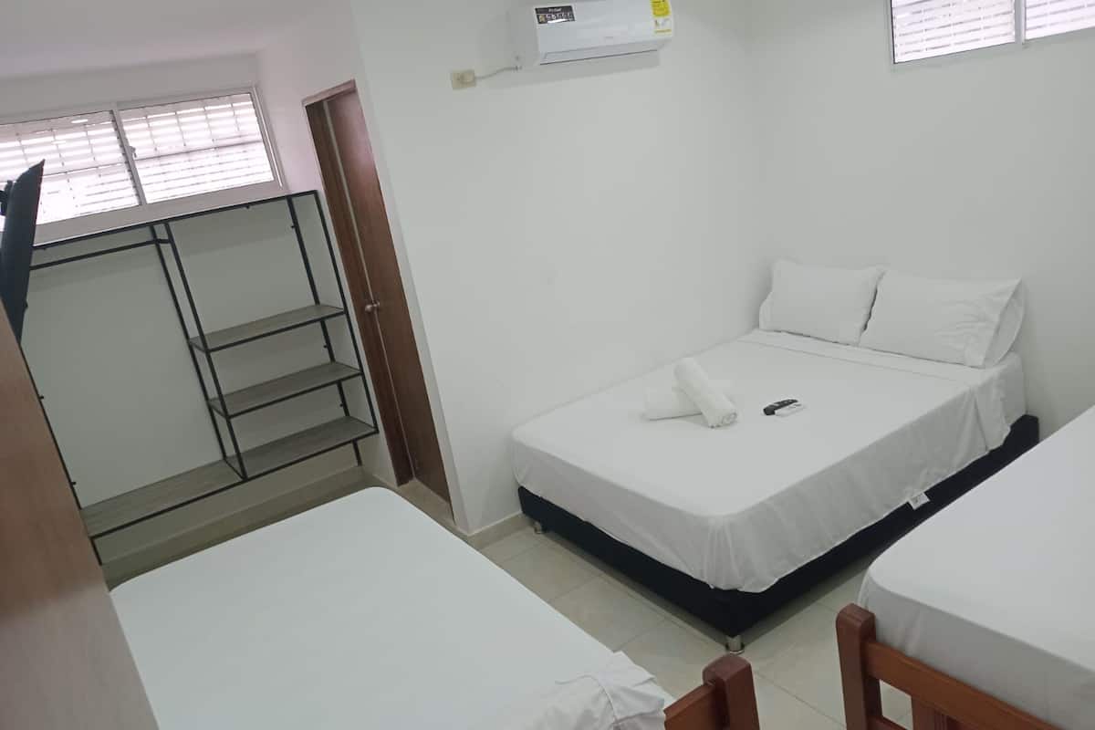 A small, clean room with a single bed, a desk, and a wardrobe.