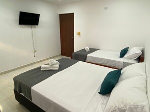 A hotel room with two single beds, a TV mounted on the wall, and a door. - 22 guest house (Santa Marta)