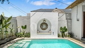 A swimming pool with a built-in bench and a decorative archway. - Kalea Villa by Kozystay - Ungasan (Ungasan)