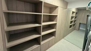Ein modernes Interieur mit integrierten Holzregalen und einer Metallvorhangstange.