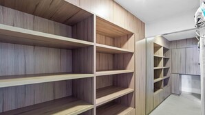 Un placard moderne doté de plusieurs étagères en bois et d’une section avec un miroir.