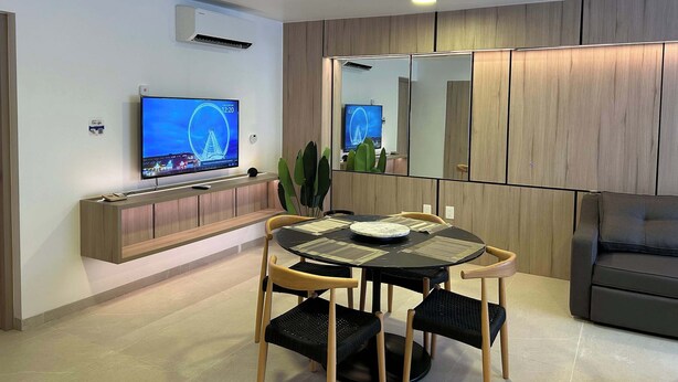 Un salon moderne comprenant un téléviseur, une table à manger, des chaises et un canapé.