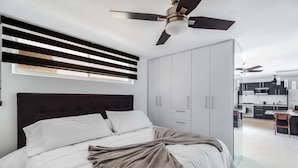 A modern bedroom with a large bed, a ceiling fan, and a wardrobe. - +MS +Deslumbrante +Suite Centrico +A11 (Santiago de Querétaro)