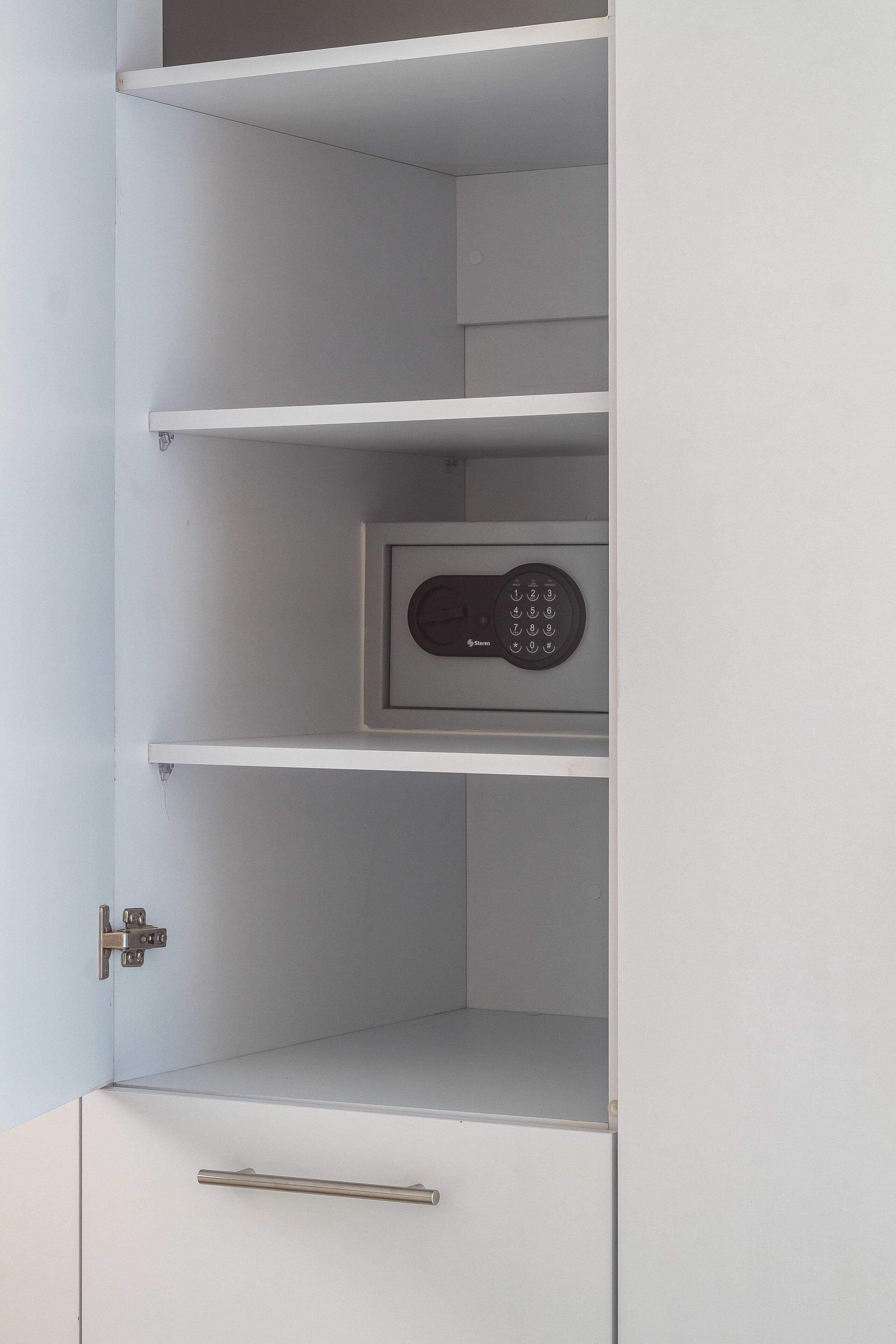 Un mueble blanco con cerradura digital y un tirador de metal.